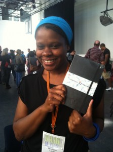 Veronica Louis holding a WordPress 10th Anniversary Notebook